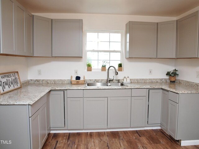 kitchen with dark wood-style flooring, a sink, and gray cabinets