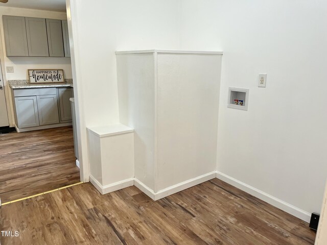 washroom featuring baseboards, washer hookup, wood finished floors, and laundry area