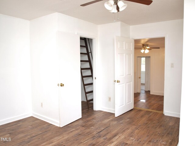 empty room featuring a ceiling fan, baseboards, and wood finished floors
