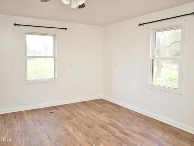 empty room with baseboards, visible vents, light wood-style floors, and a ceiling fan
