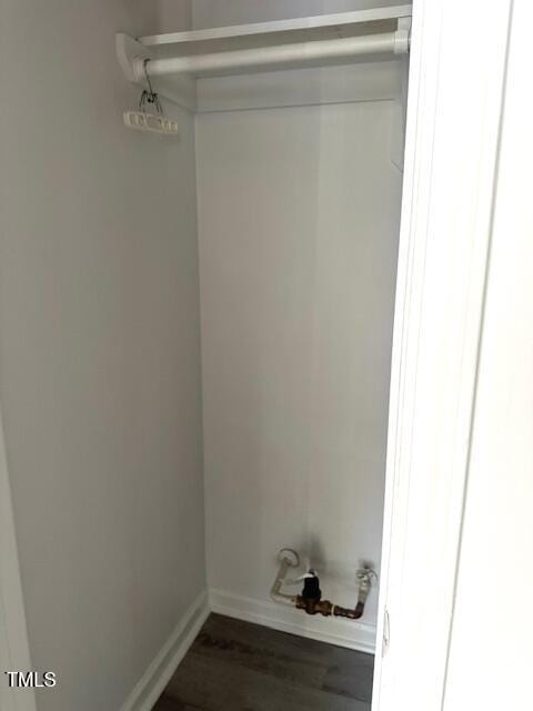 laundry area with baseboards and dark wood finished floors