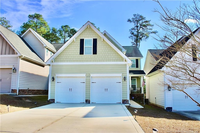 craftsman inspired home featuring a garage and concrete driveway