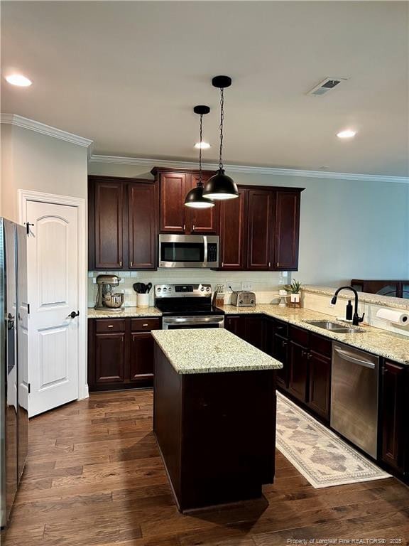kitchen featuring dark wood-style floors, a sink, stainless steel appliances, and light stone countertops