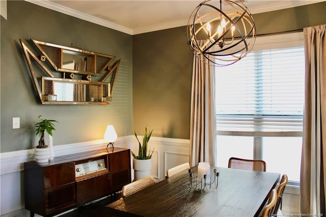 dining space featuring a wainscoted wall, a notable chandelier, crown molding, and a decorative wall