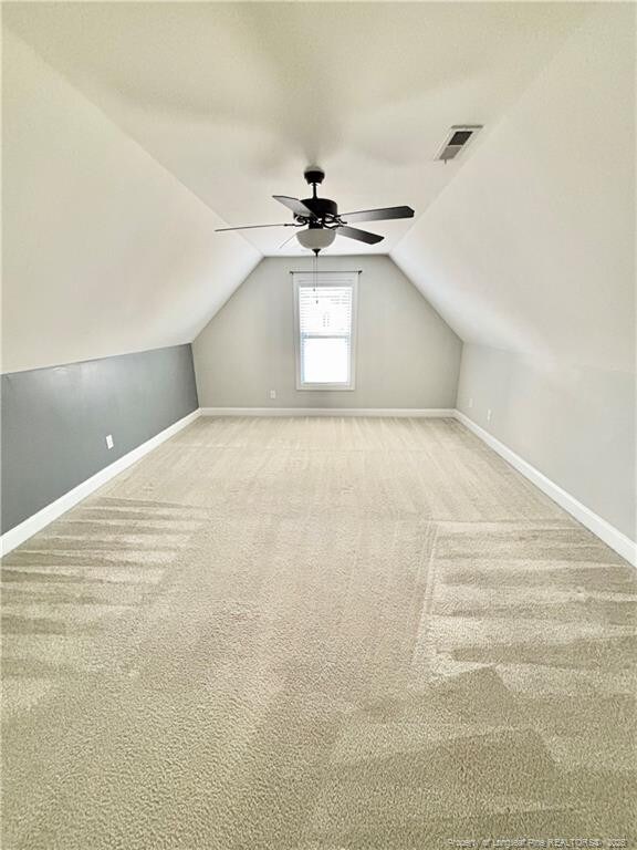 bonus room with ceiling fan, baseboards, vaulted ceiling, and visible vents