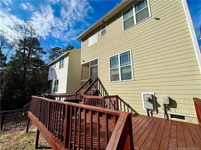 rear view of property featuring fence and a deck