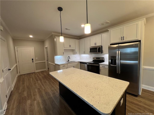 kitchen with crown molding, a sink, white cabinetry, stainless steel appliances, and dark wood-style flooring
