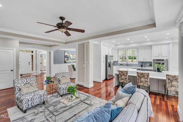 living area with wood finished floors, recessed lighting, crown molding, and ceiling fan