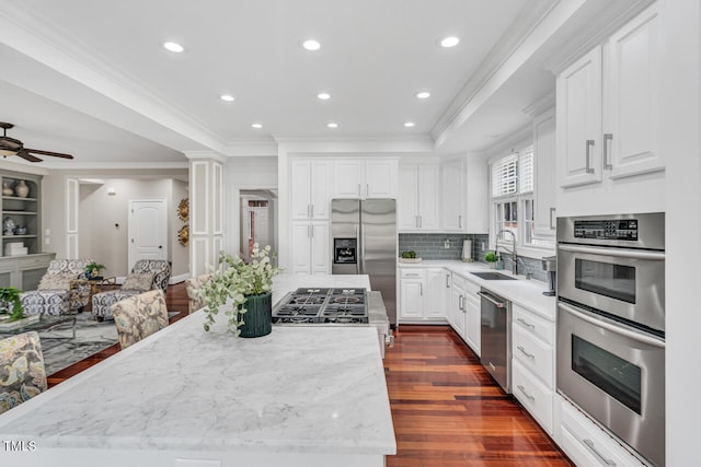 kitchen featuring white cabinetry, a sink, stainless steel appliances, and dark wood finished floors