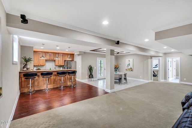 interior space featuring light colored carpet, recessed lighting, ornamental molding, baseboards, and indoor wet bar