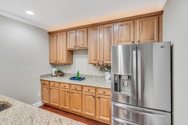 kitchen featuring stainless steel fridge, recessed lighting, ornamental molding, light stone counters, and wood finished floors