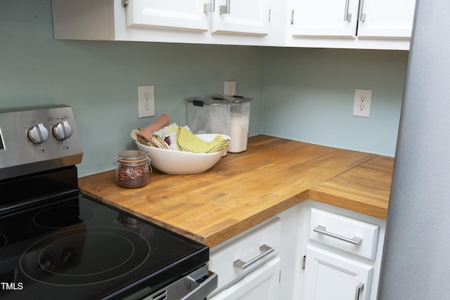 109 Perry Farms Dr, Apex, NC 27502 - kitchen view of stainless steel electric range, wooden counters, and white cabinetry