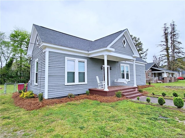 bungalow featuring a front yard and a shingled roof