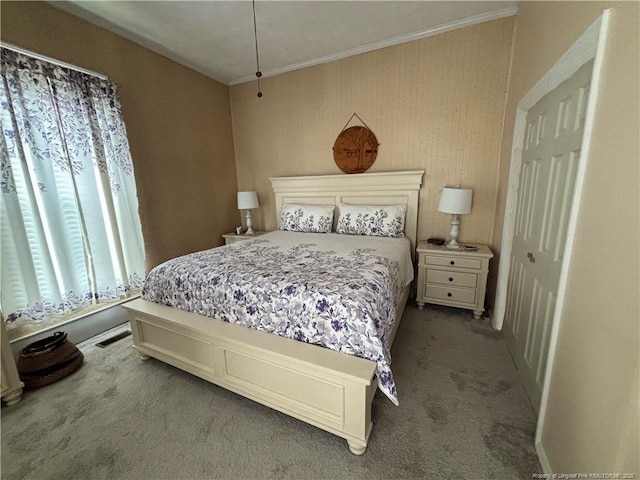 bedroom with carpet flooring, visible vents, and crown molding