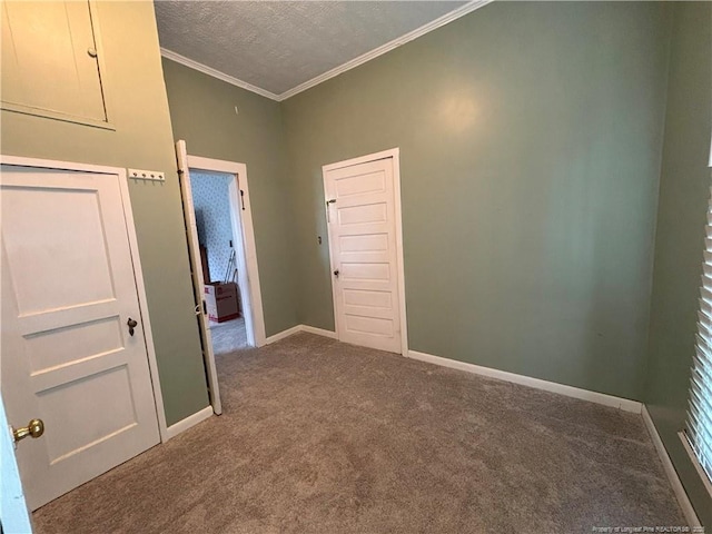 carpeted spare room featuring baseboards, a textured ceiling, and ornamental molding
