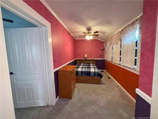 bedroom with vaulted ceiling, carpet, ceiling fan, and ornamental molding