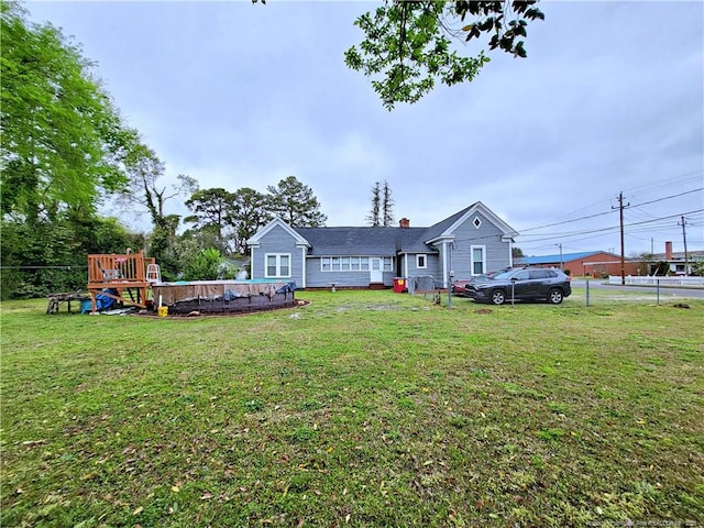 view of front of home with a chimney, a fenced in pool, and a front lawn