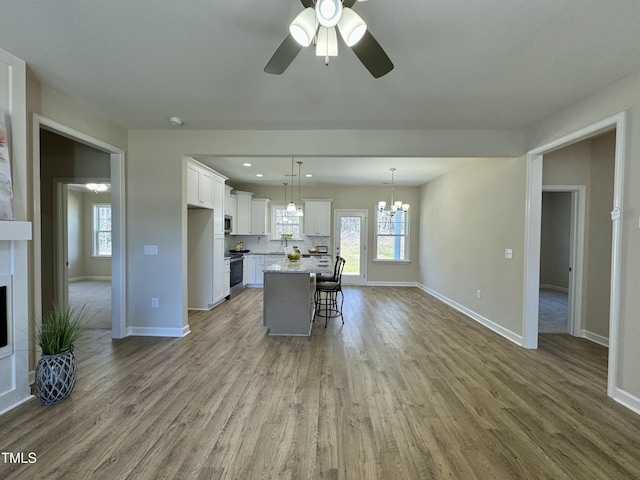 1572 Patterson Rd, Kinston, NC 28504 - kitchen with baseboards, white cabinetry, a kitchen bar, wood finished floors, and recessed lighting