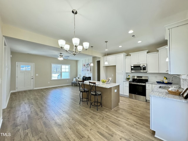 1572 Patterson Rd, Kinston, NC 28504 - kitchen featuring appliances with stainless steel finishes, a sink, a chandelier, open floor plan, and light wood-type flooring