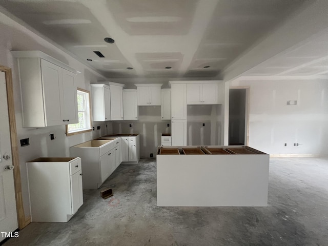 1572 Patterson Rd, Kinston, NC 28504 - kitchen featuring a kitchen island, unfinished concrete floors, and white cabinetry