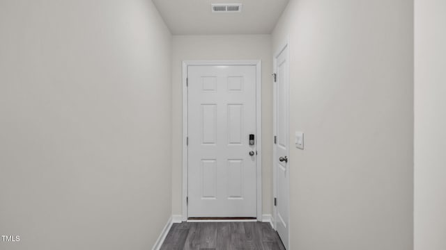 doorway to outside with baseboards, visible vents, and dark wood-style flooring