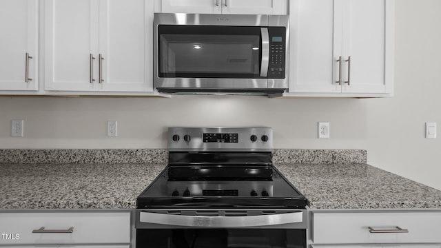 kitchen with white cabinets, stainless steel appliances, and light stone counters