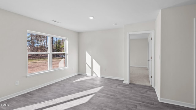unfurnished room featuring wood finished floors, recessed lighting, baseboards, and visible vents