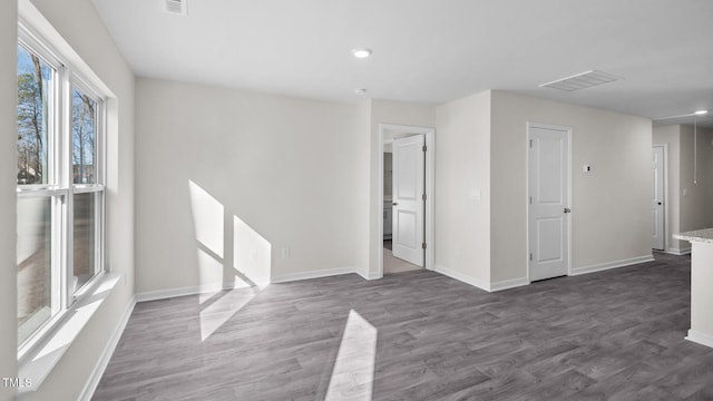 spare room with baseboards, visible vents, recessed lighting, and dark wood-type flooring