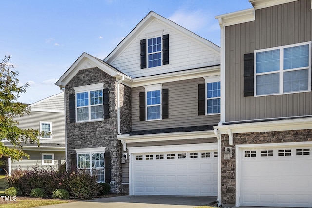 view of front of house with an attached garage, stone siding, and concrete driveway