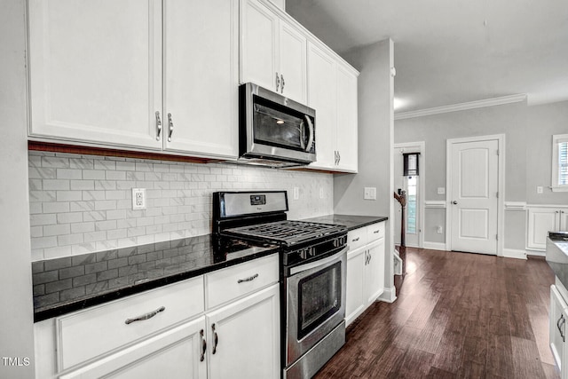 kitchen featuring crown molding, dark wood-type flooring, white cabinets, stainless steel appliances, and backsplash