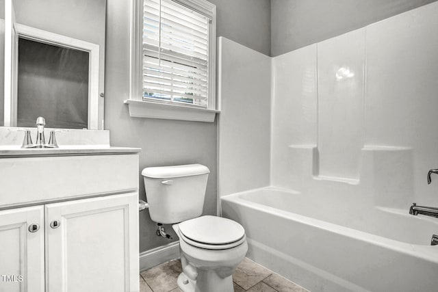 bathroom featuring washtub / shower combination, vanity, baseboards, tile patterned floors, and toilet
