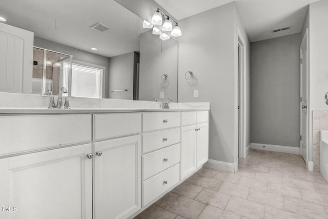 full bathroom with baseboards, double vanity, a sink, and visible vents