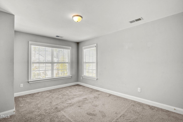 unfurnished room featuring baseboards, visible vents, and carpet floors