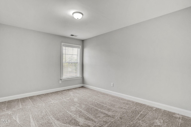 spare room featuring baseboards, visible vents, and carpet floors
