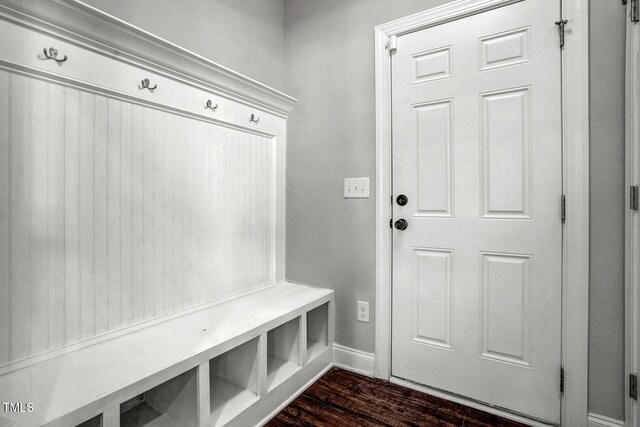 mudroom featuring dark wood-type flooring and baseboards
