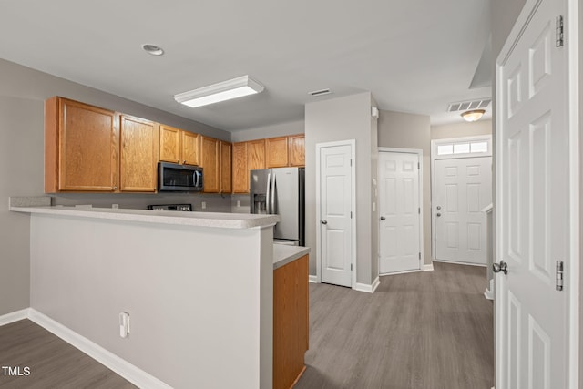 kitchen with stainless steel appliances, wood finished floors, baseboards, and light countertops