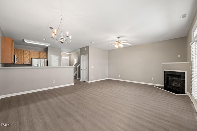 unfurnished living room featuring a ceiling fan, wood finished floors, a premium fireplace, and baseboards
