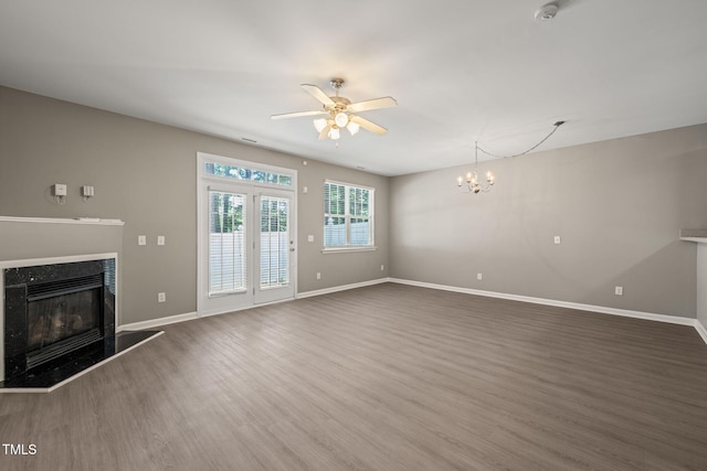 unfurnished living room featuring a ceiling fan, wood finished floors, a premium fireplace, and baseboards