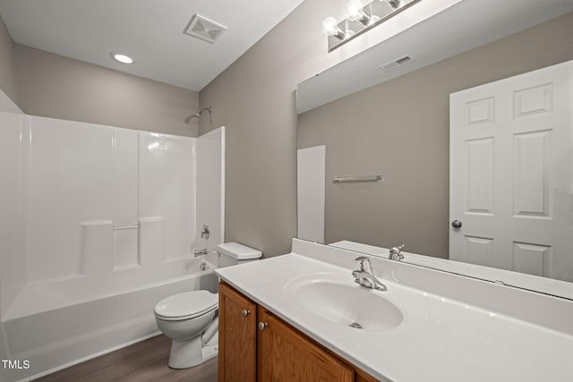 full bath with toilet, wood finished floors, vanity, and bathtub / shower combination