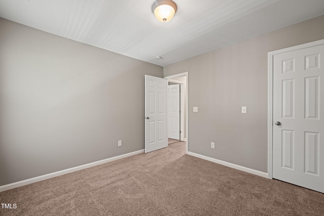 unfurnished bedroom featuring carpet floors and baseboards