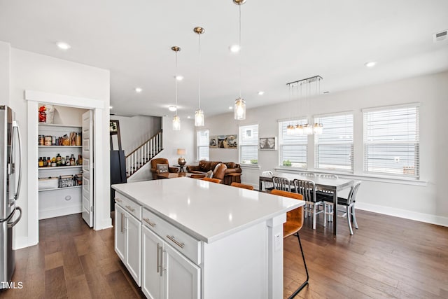 249 Wendover Pkwy, Pittsboro, NC 27312 - kitchen with a breakfast bar, dark wood-style floors, a center island, light countertops, and white cabinets