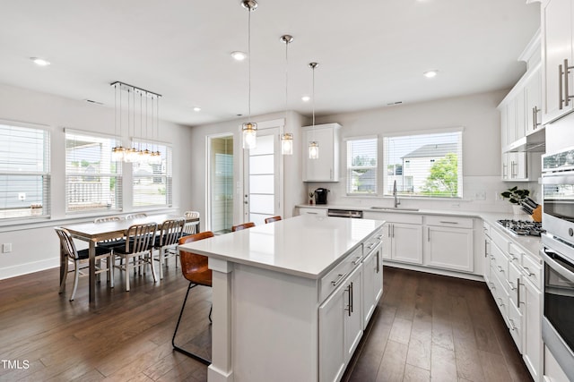 249 Wendover Pkwy, Pittsboro, NC 27312 - kitchen featuring a sink, appliances with stainless steel finishes, dark wood-type flooring, light countertops, and a kitchen island