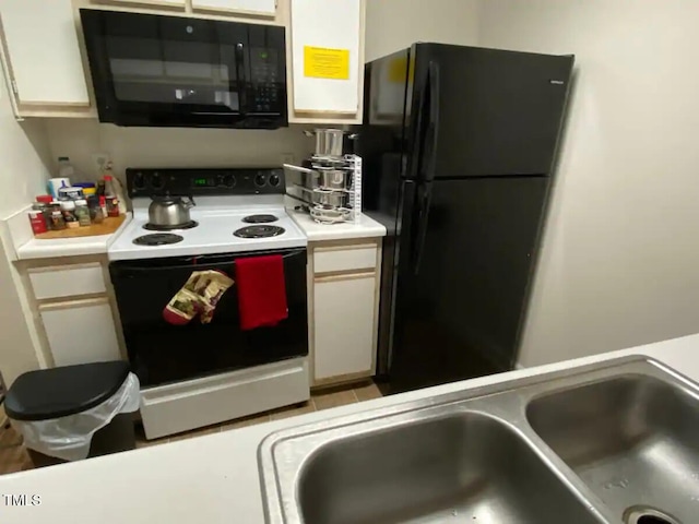 303 Smith Level Rd Unit E33, Chapel Hill, NC 27516 - kitchen featuring black appliances, a sink, light countertops, and white cabinets