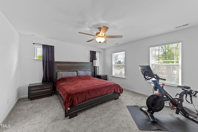 bedroom with baseboards, visible vents, carpet floors, and multiple windows