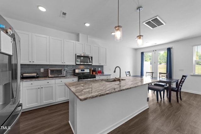 kitchen with dark wood-style flooring, stainless steel appliances, visible vents, and a sink
