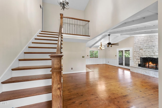 6601 Hidden Pond Rd, Wendell, NC 27591 - unfurnished living room with hardwood / wood-style floors, a stone fireplace, a chandelier, beam ceiling, and stairs