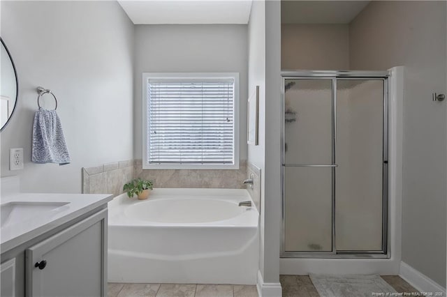 full bath featuring tile patterned flooring, vanity, a stall shower, and a garden tub