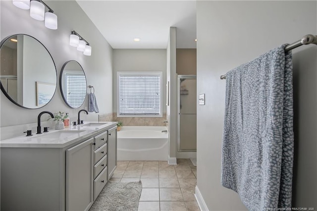 bathroom with a shower stall, tile patterned floors, double vanity, and a sink