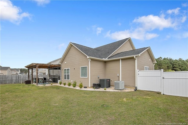 rear view of property featuring central air condition unit, a fenced backyard, a yard, and a patio area