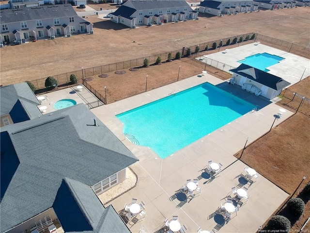 community pool with a fenced backyard, a hot tub, and a patio area